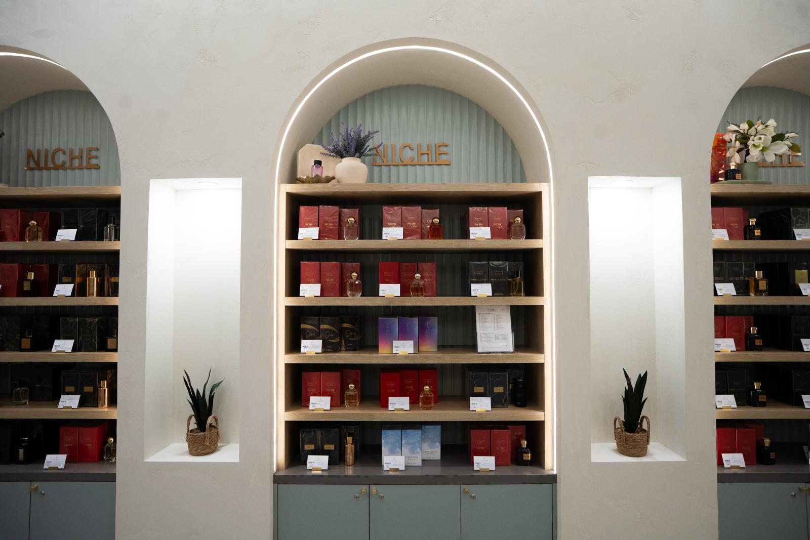 Modern retail shelving display with arched alcoves, illuminated neon signage, and contemporary product arrangement