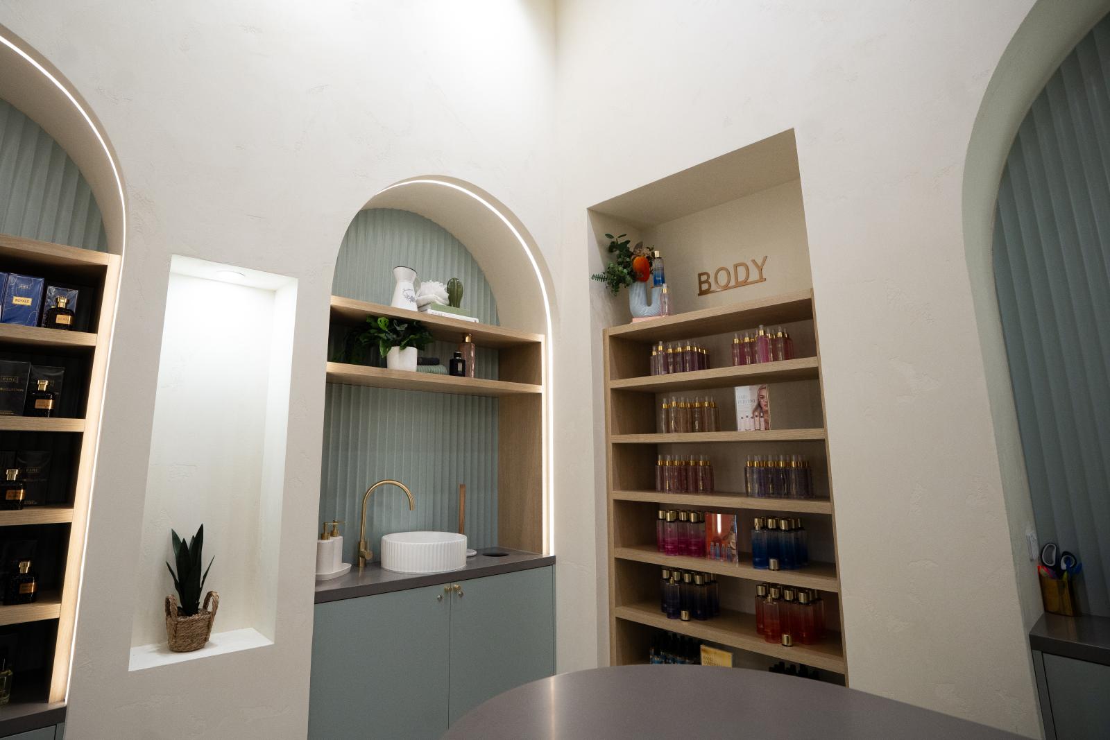 Contemporary minimalist office space with arched alcoves, built-in shelving, and grey accent features