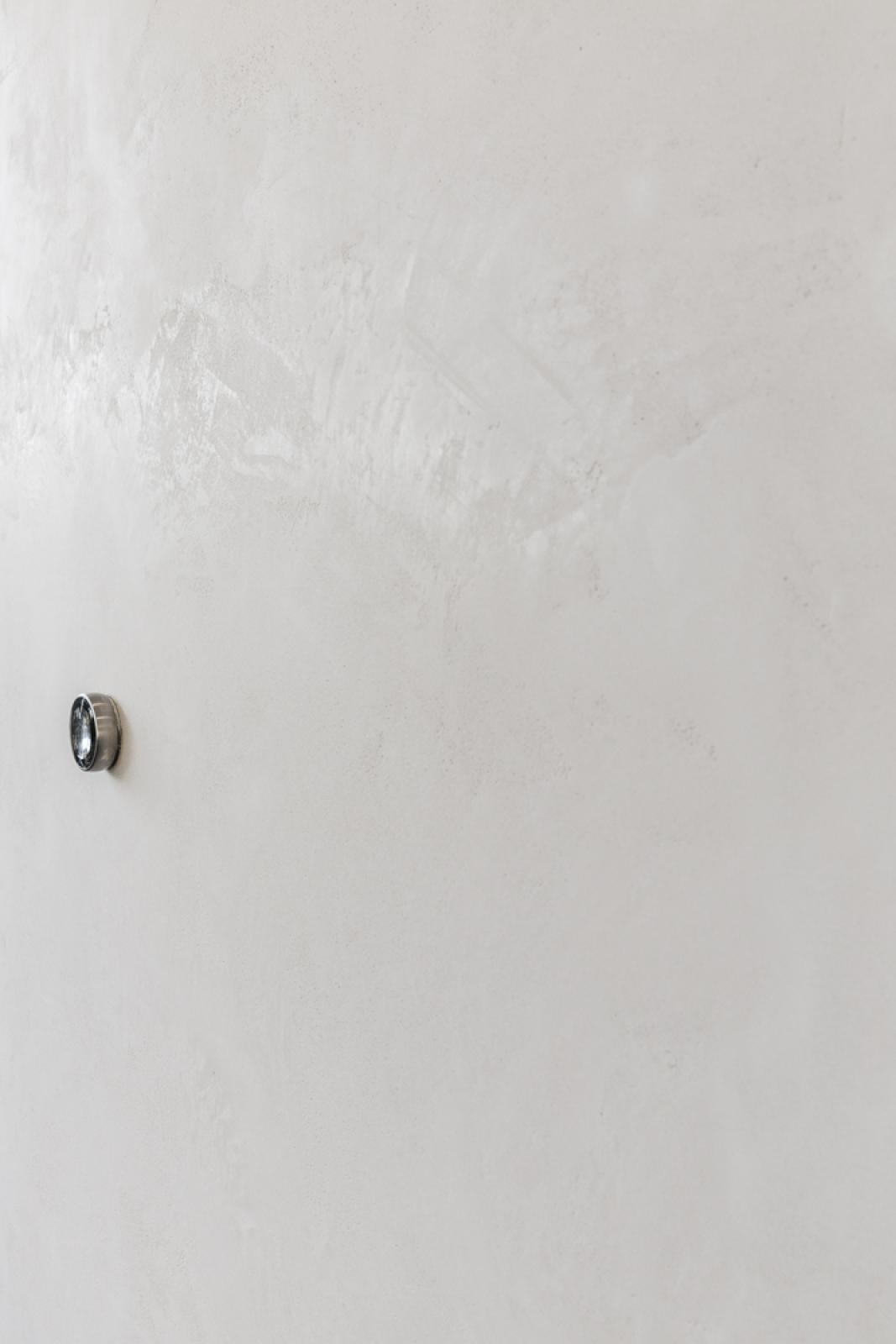 Polished concrete wall with chrome ceiling fixture during home renovation