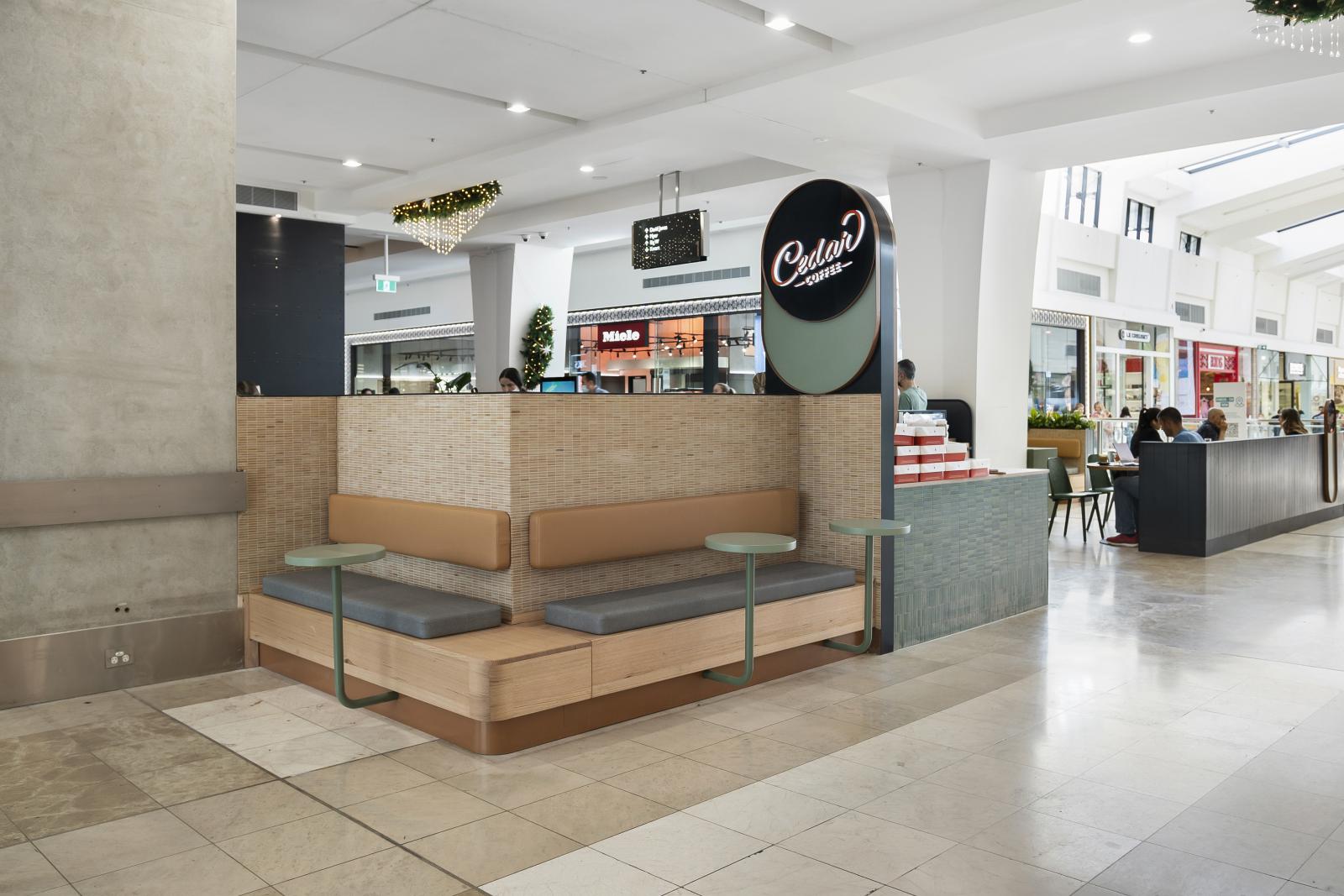 Modern café fitout with curved timber counter, pendant lighting, and open-plan layout